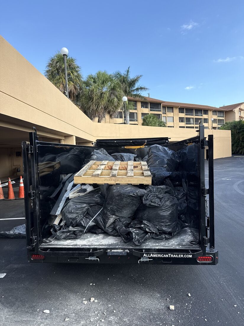 Trailer loaded with bagged construction debris and a pallet